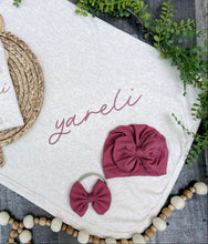 Load image into Gallery viewer, Baby accessories including headbands and a basket on a textured surface with greenery.
